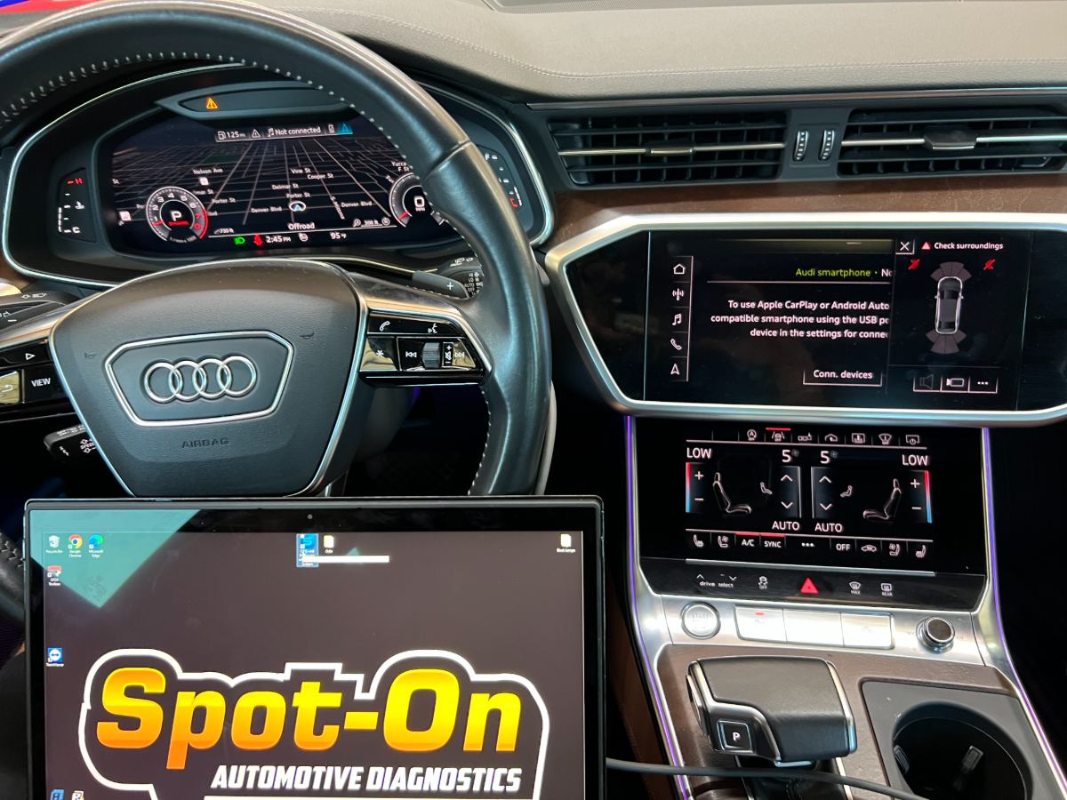 Audi A6 cabin with Audi steering wheel, virtual cockpit and MMI active, Spot-On Automotive Diagnostics laptop in the foreground running ODIS