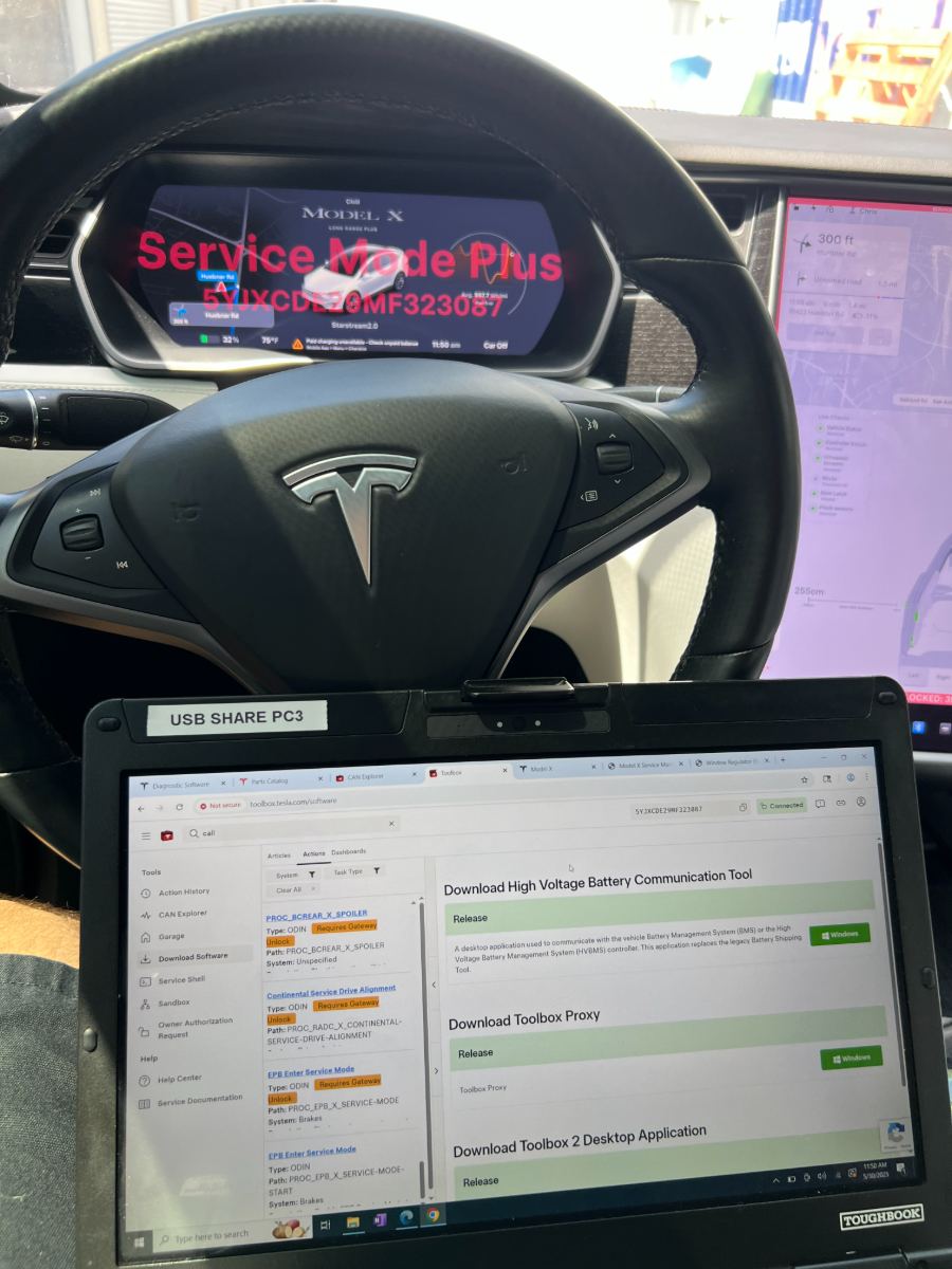 Tesla Model X interior with Service Mode Plus on the dash cluster and Toolbox software open on a connected Panasonic Toughbook