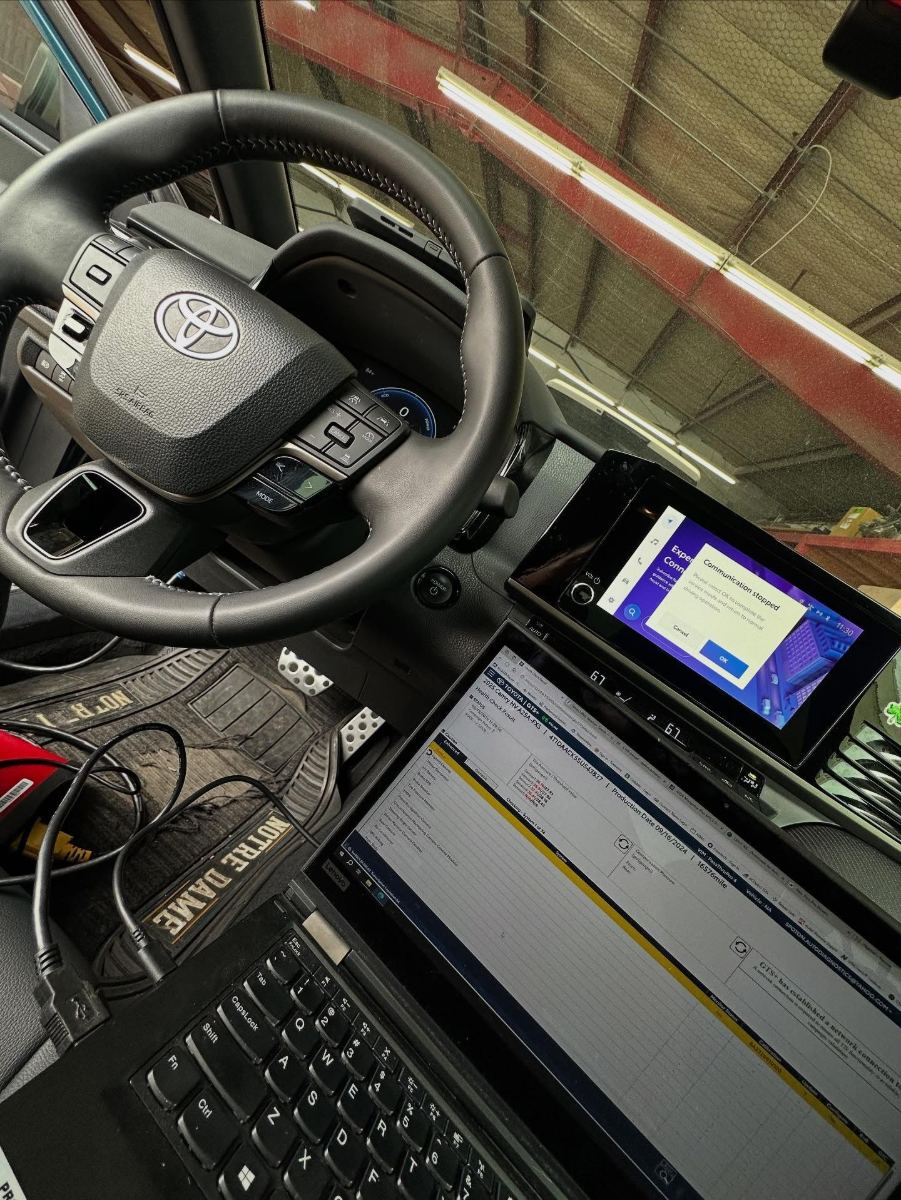 Toyota Camry Hybrid steering wheel with Toyota GTS+ health check running on a connected Lenovo laptop